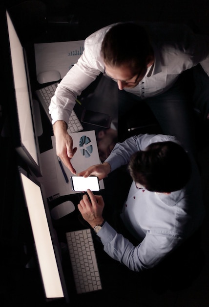 Foto colegas de negócios de visão superior usando gadgets para trabalhar com dados financeirosnegócios e tecnologia