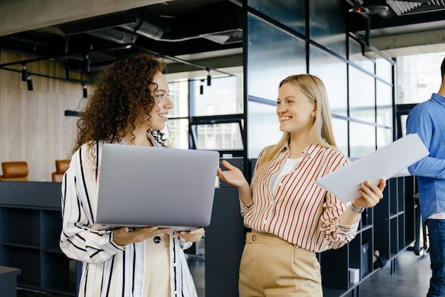 Colegas de negócios felizes usando laptop discutindo a ideia