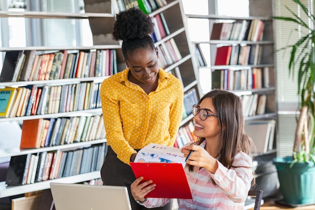 Colegas de negócios mulher estão trabalhando com laptop falando compartilhando idéias de negócios no escritório moderno