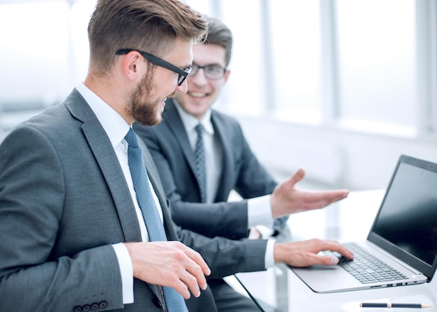 Colegas de negócios próximos discutem informações atuais sentadas na mesa do escritório