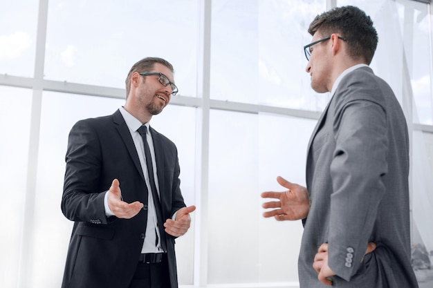 Colegas de negócios vista inferior falando em pé no conceito officebusiness