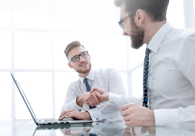 Colegas de negócios vista lateral apertando as mãos no local de trabalho