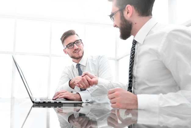 Colegas de negócios vista lateral apertando as mãos no local de trabalho