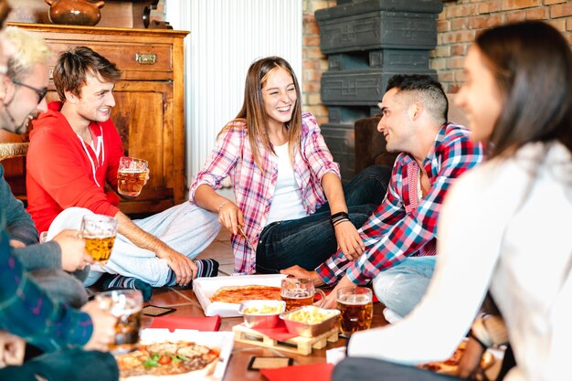 Colegas de quarto felizes comendo pizza take away em casa depois da faculdade