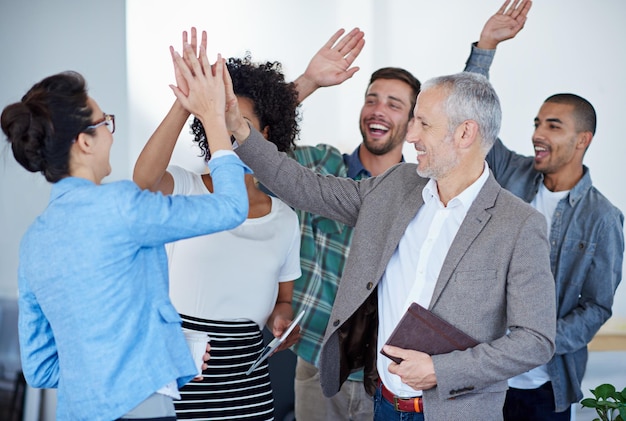 Colegas de trabalho a darem um "high five" no escritório.