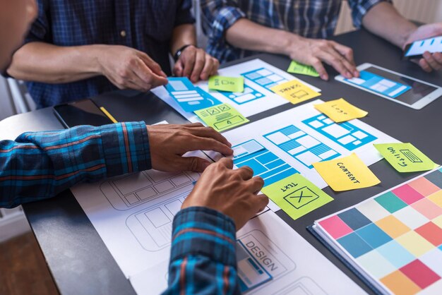 Colegas de trabalho a discutir papelada na mesa do escritório.