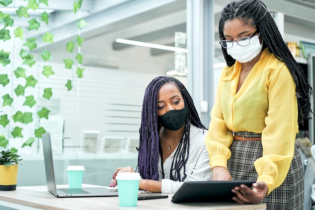 Colegas de trabalho afro-americanas falam sobre trabalhar juntas em reunião de escritório