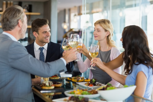 Foto colegas de trabalho, brindar copos de cerveja enquanto almoça