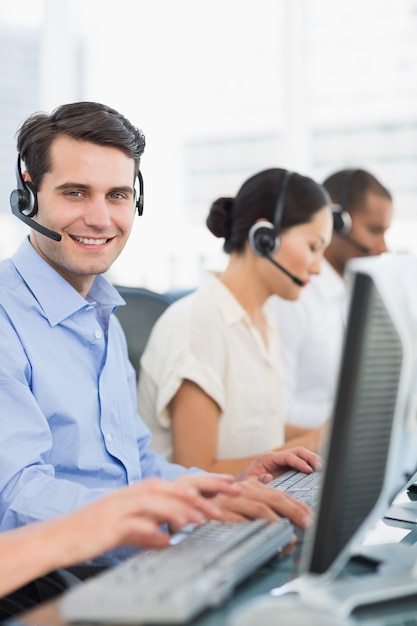 Foto colegas de trabalho com fones de ouvido usando computadores