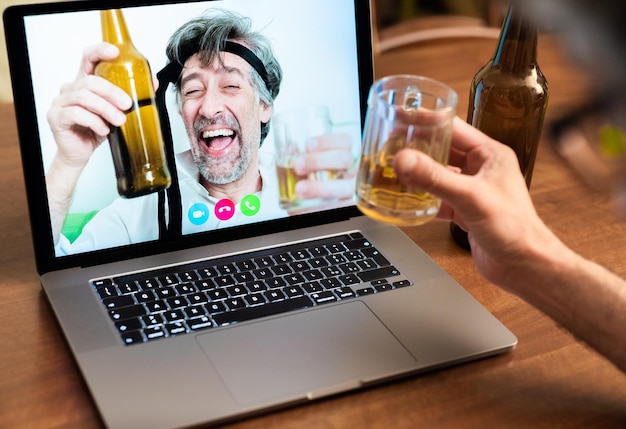 Foto colegas de trabalho comemoram o sucesso ficando bêbados com cervejas em videochamadas de longa distância, amigos levantam os cotovelos durante uma videochamada