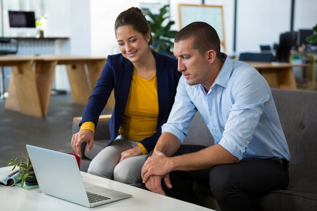 Colegas de trabalho, discutindo sobre laptop