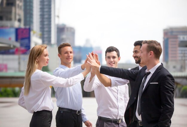 Foto colegas de trabalho empilhando as mãos enquanto estão ao ar livre