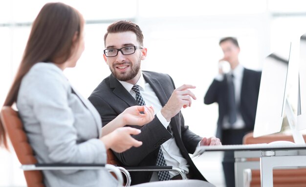 Colegas de trabalho falando em sua mesa