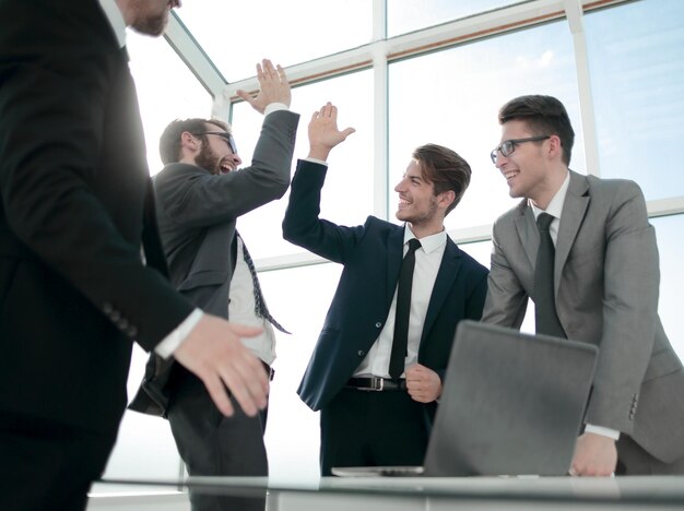 Colegas de trabalho felizes dando uns aos outros cinco conceitos de sucesso