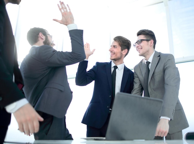 Colegas de trabalho felizes dando uns aos outros cinco