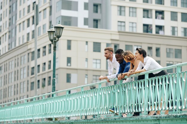 Colegas de trabalho felizes em pé na ponte