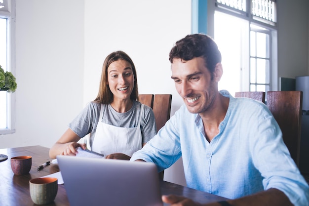 Colegas de trabalho freelance animados usando laptop