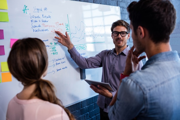 Colegas de trabalho interagindo frente de uma placa