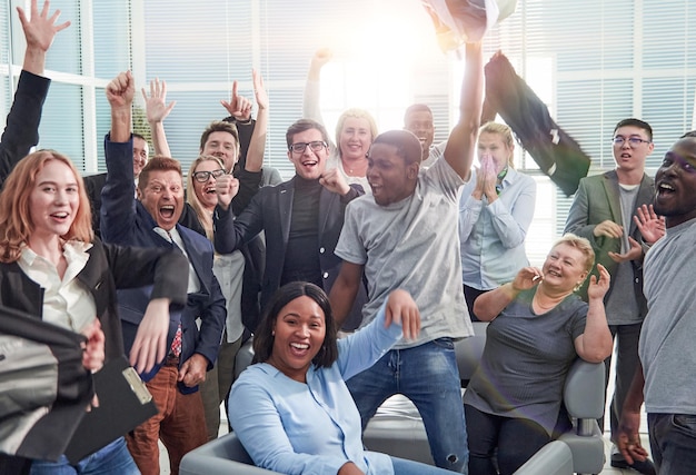 Colegas de trabalho multiétnicos felizes comemorando uma vitória no escritório