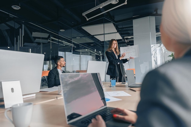 Colegas de trabalho multiétnicos ocupados cooperando e trabalhando juntos no escritório, reunindo o conceito de trabalho em equipe