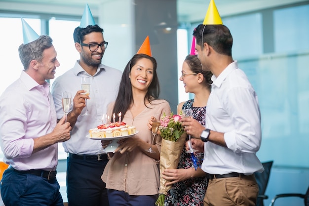 Colegas de trabalho sorridentes comemorando aniversário