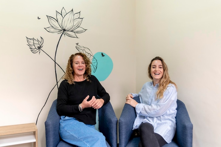 Foto colegas de trabalho sorrindo enquanto relaxam sentadas em poltronas durante uma pausa no trabalho
