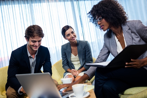 Colegas de trabalho tendo reunião em torno da mesa