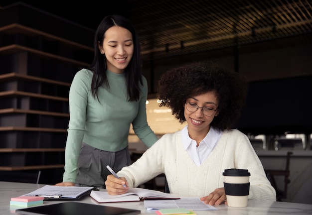 Colegas de trabalho trabalhando e escrevendo em um notebook