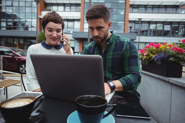 Colegas de trabalho, trabalhando enquanto tomando café na cantina