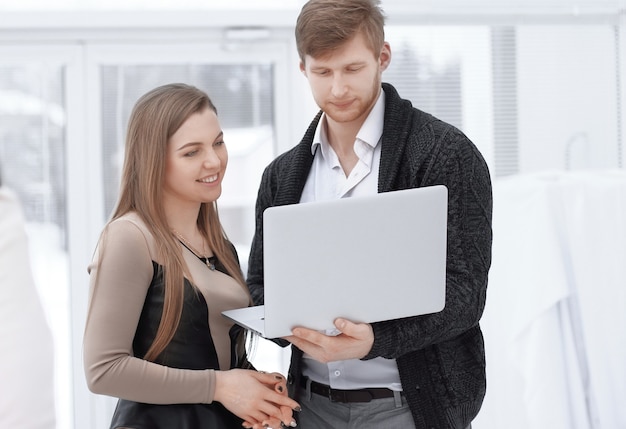 Colegas de trabalho usam um laptop no escritório