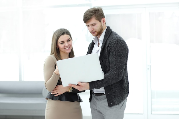 Colegas de trabalho usam um laptop no escritório