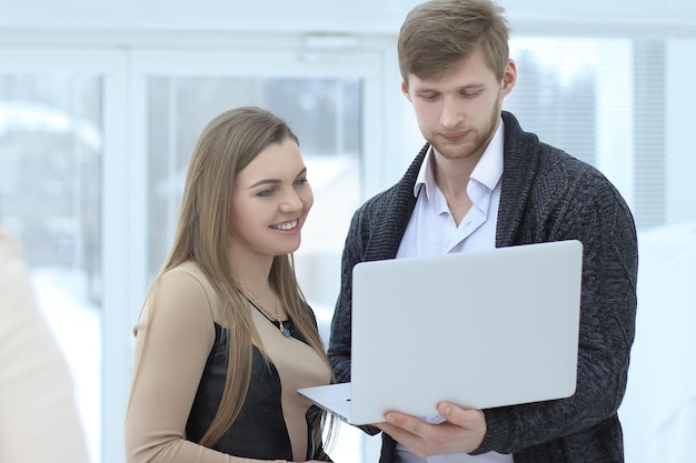 Colegas de trabalho usam um laptop no escritório