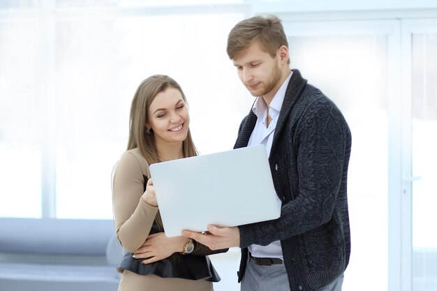 Colegas de trabalho usam um laptop no escritório