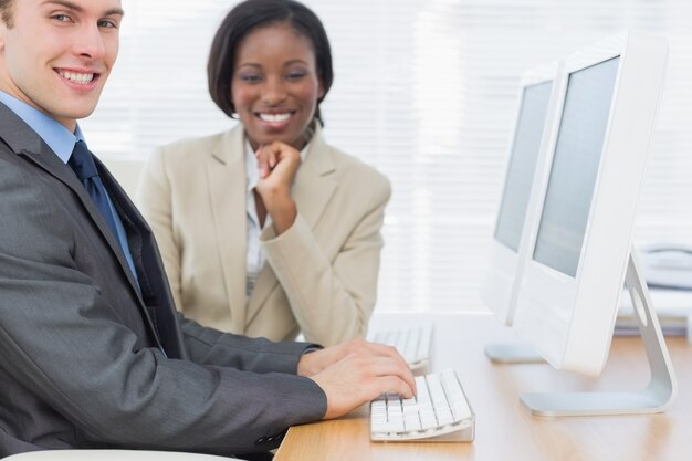 Colegas de trabalho usando computadores na mesa