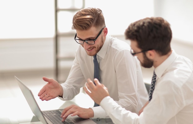 Colegas de trabalho usando um laptop para verificar dados o conceito de profissionalismo