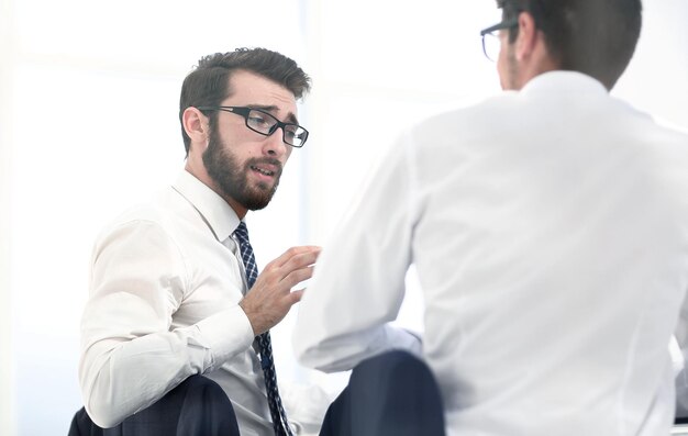 Colegas de visão traseira discutem algo sentado no conceito Deskbusiness