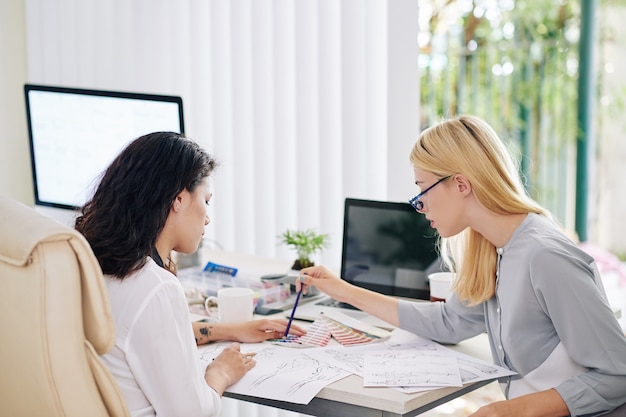 Colegas discutindo esboços de moda