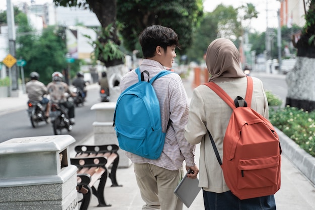 Colegas estudiantes asiáticos caminando en la ciudad