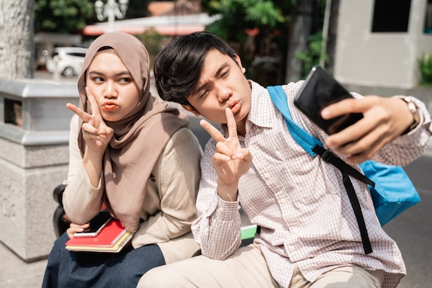 Colegas estudiantes asiáticos tomando una selfie