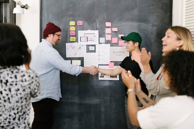 Colegas felices tomados de la mano en la oficina