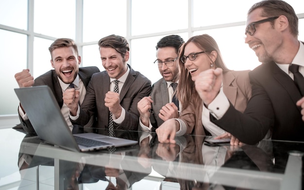 Colegas felizes na mesa levantam as mãos