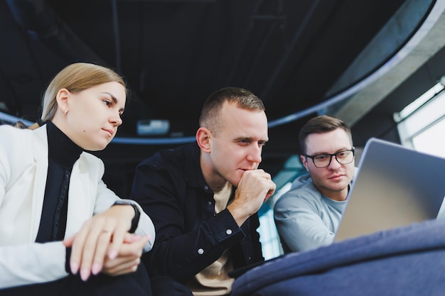 Los colegas de la gente de negocios discuten negocios mirando el espacio de trabajo moderno de la computadora portátil Los colegas trabajan juntos en la oficina