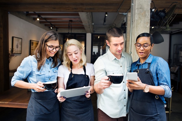 Colegas jugando en dispositivos digitales en una cafetería