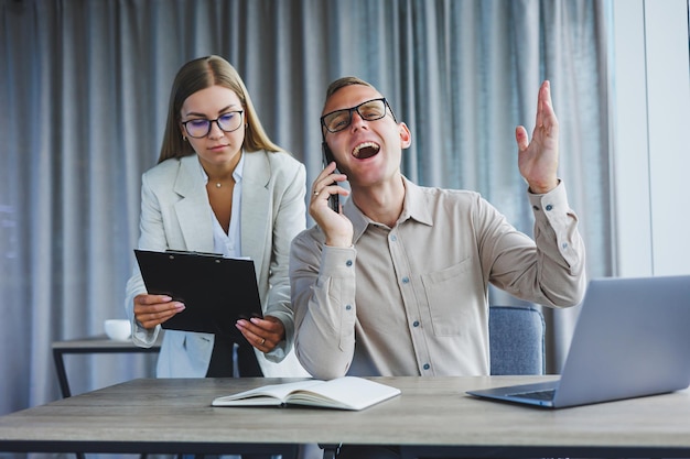 Colegas masculinos e femininos debatendo sobre informações do projeto em formato online durante o tempo de trabalho no escritório no computador portátil jovens parceiros de sucesso lendo notícias e compartilhando ideias no netbook