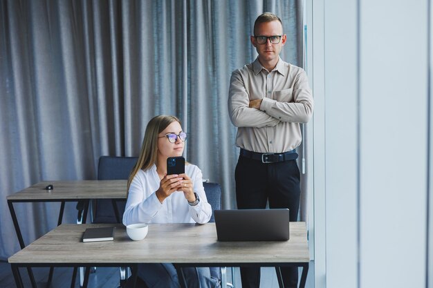 Colegas masculinos e femininos debatendo sobre informações do projeto em formato online durante o tempo de trabalho no escritório no computador portátil jovens parceiros de sucesso lendo notícias e compartilhando ideias no netbook