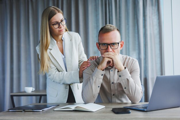 Colegas masculinos e femininos debatendo sobre informações do projeto em formato online durante o tempo de trabalho no escritório no computador portátil jovens parceiros de sucesso lendo notícias e compartilhando ideias no netbook