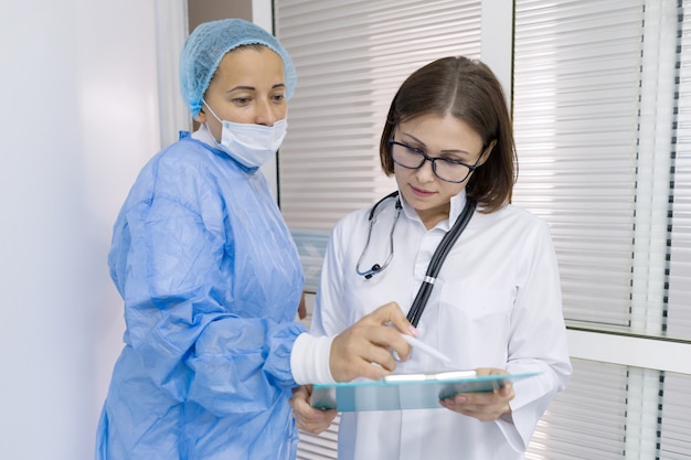 Colegas médico médico cirúrgico e terapeuta falando no hospital