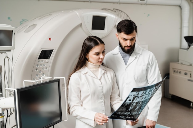 Colegas médicos discutindo xrays na sala de tomografia computadorizada de tomografia computadorizada A estagiária médica está estudando na sala de tomografia computadorizada de tomografia computadorizada em cursos de estágio