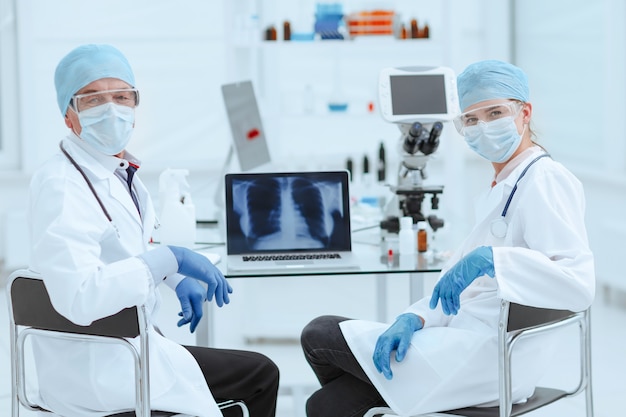 colegas médicos sentados en una mesa en el laboratorio