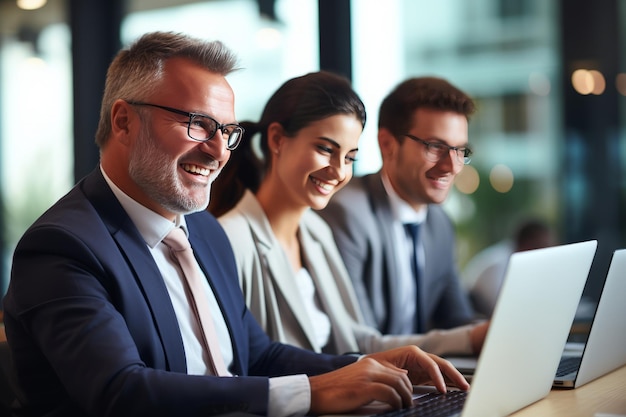 Colegas de negocios alegres viendo una presentación en una computadora portátil